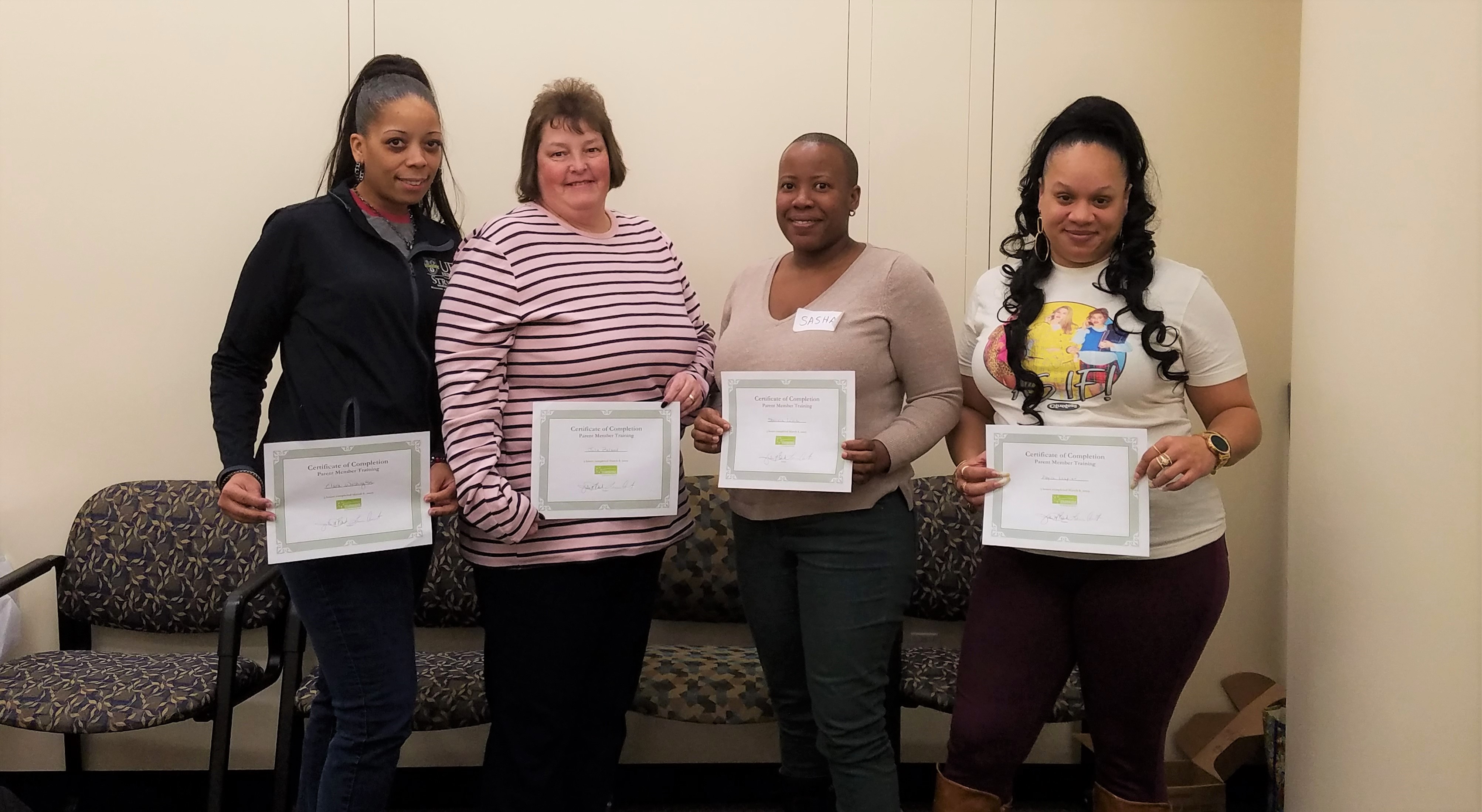 Four adult women of diverse races holding certificates of completion from a Starbridge workshop series